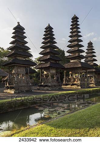 Stock Image - Moat surrounding classical tiered thatched-roofs merus (towers) in the Royal Water Temple Pura Taman Ayun, Mengwi, Bali, Indonesia. Fotosearch
