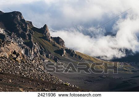 Stock Photograph - Morning clouds begin to burn off of Haleakala National Park; Maui, Hawaii, United States of America. Fotosearch