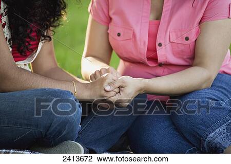 Stock Image - Mother and daughter praying together in a park; Edmonton, Alberta, Canada. Fotosearch