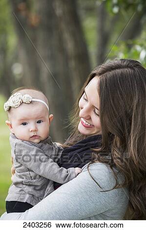 Stock Photograph - Mother and infant daughter in a park; Edmonton, Alberta, Canada. Fotosearch