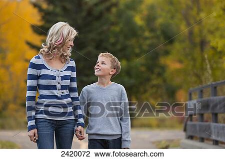 Mother and son walking and talking in a park in autumn; Edmonton, Alberta, Canada View Large Photo Image Stock Image - Mother and son walking and talking in a park in autumn; Edmonton, Alberta, Canada. Fotosearch