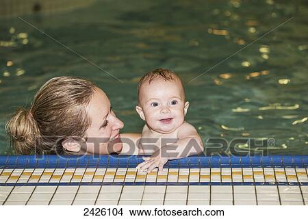 Mother teaching her infant to swim at an indoor pool; St. Albert, Alberta, Canada View Large Photo Image Picture - Mother teaching her infant to swim at an indoor pool; St. Albert, Alberta, Canada. Fotosearch