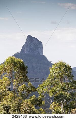 Mountain peak rising up against a blue sky and cloud, Glass House mountains; Queensland, Australia View Large Photo Image Stock Image - Mountain peak rising up against a blue sky and cloud, Glass House mountains; Queensland, Australia. Fotosearch