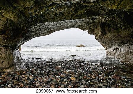 Stock Photo - Natural rock arch along the water's edge; Portland Creek, Newfoundland and Labrador, Canada. Fotosearch