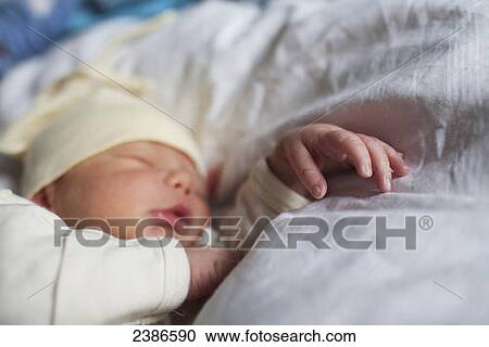Newborn sleeping with new wrinkly hand outstretched, wearing hat and onesie; Toronto, Ontario, Canada View Large Photo Image Stock Image - Newborn sleeping with new wrinkly hand outstretched, wearing hat and onesie; Toronto, Ontario, Canada. Fotosearch