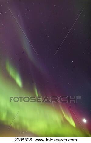 Stock Photograph - Northern Lights and the moon in the sky above the Tony Knowles Coastal Trail, Anchorage Coastal Refuge; Anchorage, Alaska, United States of America. Fotosearch