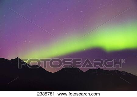 Stock Image - Northern Lights in the sky above Moose Pass, silhouetted Kenai Mountains in the foreground, Chugach National Forest; Alaska, United States of America. Fotosearch