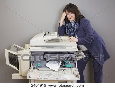 Office worker frustrated with paper jam in photocopier; Edmonton, Alberta, Canada View Large Photo Image Stock Photography - Office worker frustrated with paper jam in photocopier; Edmonton, Alberta, Canada. Fotosearch