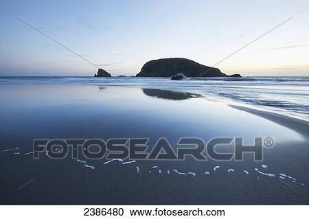 Stock Image - Pacific ocean and coast of Oregon with a large rock at sunset; Oregon, United States of America. Fotosearch