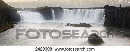 Panoramic view of Gooafoss waterfall, with photographer standing on edge showing it's scale; Iceland View Large Photo Image Stock Photo - Panoramic view of Gooafoss waterfall, with photographer standing on edge showing it's scale; Iceland. Fotosearch