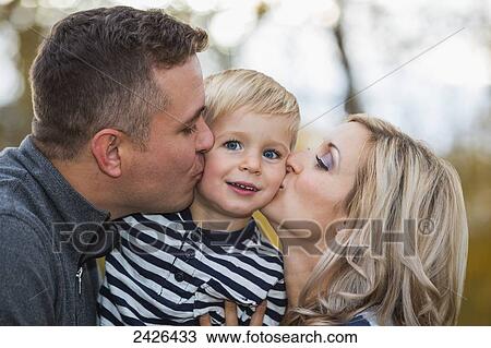 Parents kissing their young son in a park; Edmonton, Alberta, Canada View Large Photo Image Stock Image - Parents kissing their young son in a park; Edmonton, Alberta, Canada. Fotosearch
