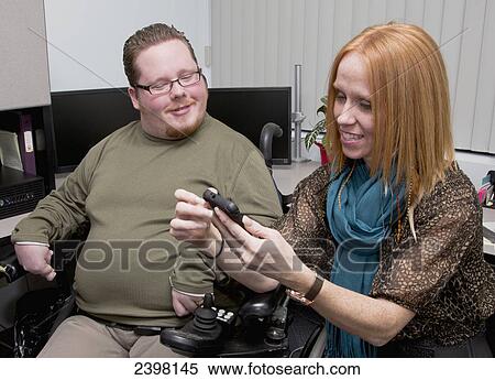 Stock Photography - Persons with spinal cord injury working together in a business setting; Edmonton, Alberta, Canada. Fotosearch