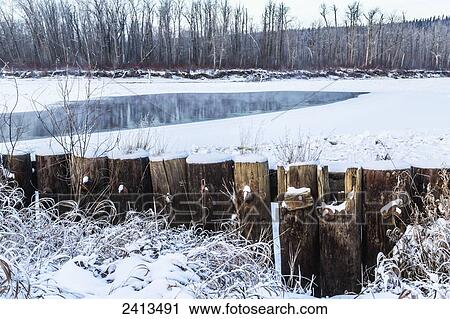 Pillars of an old bridge stick out from the snow by a frozen river; Fort McMurray, Alberta, Canada View Large Photo Image Stock Image - Pillars of an old bridge stick out from the snow by a frozen river; Fort McMurray, Alberta, Canada. Fotosearch