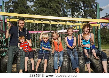 Portrait of a family of seven sitting on tires at a playground; Stony Plain, Alberta, Canada View Large Photo Image Stock Image - Portrait of a family of seven sitting on tires at a playground; Stony Plain, Alberta, Canada. Fotosearch