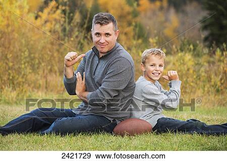 Portrait of a father and son pointing to each other to say who lost the game of football in the park; Edmonton, Alberta, Canada View Large Photo Image Stock Photo - Portrait of a father and son pointing to each other to say who lost the game of football in the park; Edmonton, Alberta, Canada. Fotosearch