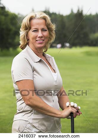 Stock Photo - Portrait of a female golfer on a golf course; Edmonton, Alberta, Canada. Fotosearch