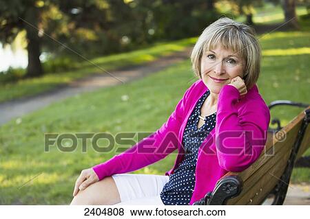 Portrait of a mature woman sitting on a park bench; Edmonton, Alberta, Canada View Large Photo Image Stock Photo - Portrait of a mature woman sitting on a park bench; Edmonton, Alberta, Canada. Fotosearch