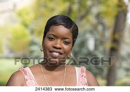 Stock Image - Portrait of a woman in a park; Edmonton, Alberta, Canada. Fotosearch