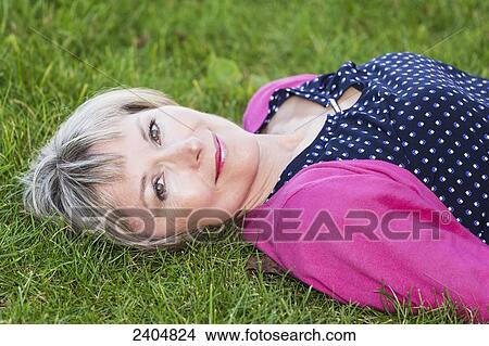 Portrait of a woman laying on the grass in a park; Edmonton, Alberta, Canada View Large Photo Image Picture - Portrait of a woman laying on the grass in a park; Edmonton, Alberta, Canada. Fotosearch