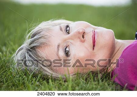 Portrait of a woman laying on the grass; Edmonton, Alberta, Canada View Large Photo Image Stock Image - Portrait of a woman laying on the grass; Edmonton, Alberta, Canada. Fotosearch