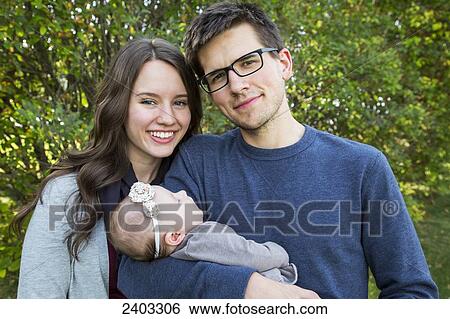 Portrait of a young couple with infant daughter; Edmonton, Alberta, Canada View Large Photo Image Stock Photograph - Portrait of a young couple with infant daughter; Edmonton, Alberta, Canada. Fotosearch
