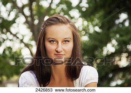 Stock Image - Portrait of a young woman in a park; St. Albert, Alberta, Canada. Fotosearch