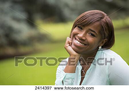 Stock Photo - Portrait of a young woman in a park; Edmonton, Alberta, Canada. Fotosearch