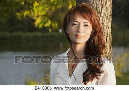 Stock Photography - Portrait of a young woman in a park; Edmonton, Alberta, Canada. Fotosearch