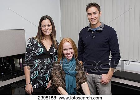 Portrait of co-workers together, one with a disability; Edmonton, Alberta, Canada View Large Photo Image Stock Photo - Portrait of co-workers together, one with a disability; Edmonton, Alberta, Canada. Fotosearch
