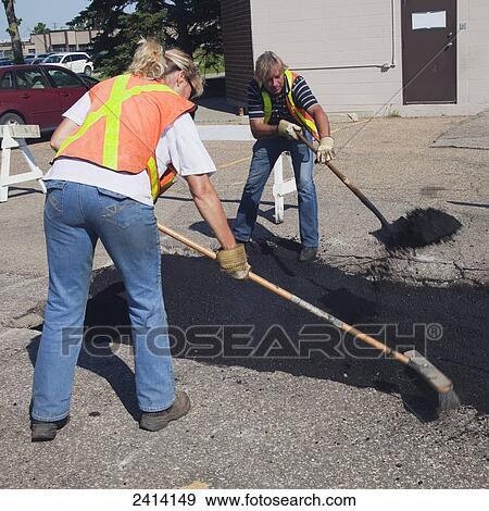 Stock Photo - Pot hole work crew repairing a parking lot; Edmonton, Alberta, Canada. Fotosearch