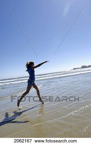 Stock Photo - Pre-Teen Girl Running On Beach, Vancouver Island, B. C.. Fotosearch