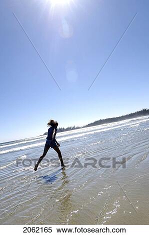 Stock Photography - Pre-Teen Girl Running On Beach, Vancouver Island, B. C.. Fotosearch