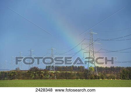 Stock Photo - Rainbow behind high voltage electricity cables near Great Wilbraham; Cambridgeshire, England. Fotosearch