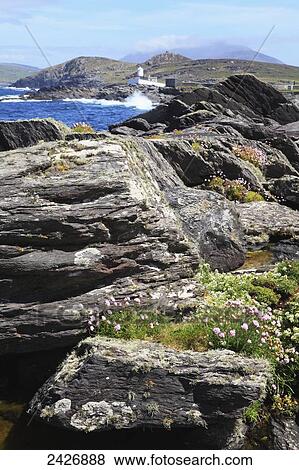 Stock Photo - Rocky coastline and lighthouse; Valentia Island, County Kerry, Ireland. Fotosearch