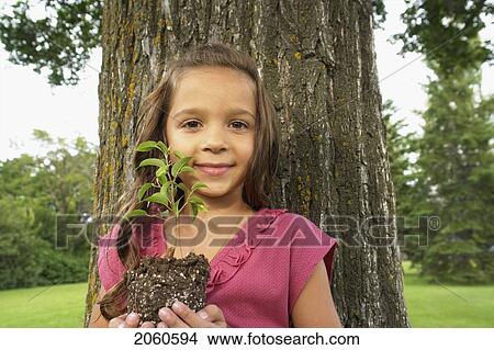 Seven Year Old Girl Holding Seedling Beside Tree, Winnipeg, Canada View Large Photo Image Picture - Seven Year Old Girl Holding Seedling Beside Tree, Winnipeg, Canada. Fotosearch