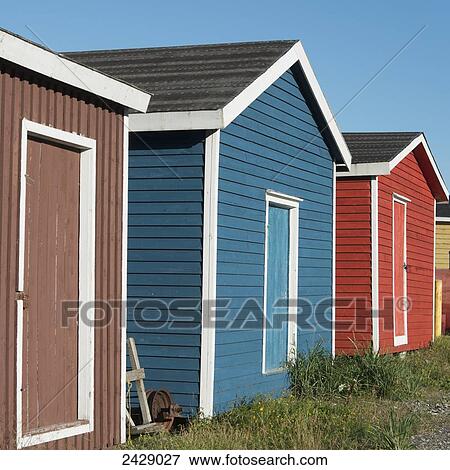 Stock Photo - Sheds in various colours in a row; Trout River, Newfoundland, Canada. Fotosearch