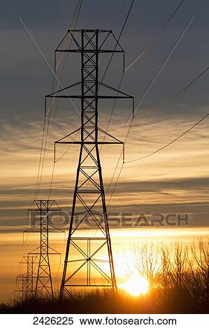 Silhouetted electric towers with wires at sunrise with orange cast clouds and blue sky; Calgary, Alberta, Canada View Large Photo Image Stock Photography - Silhouetted electric towers with wires at sunrise with orange cast clouds and blue sky; Calgary, Alberta, Canada. Fotosearch
