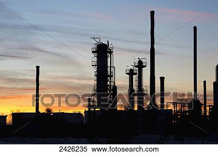 Silhouetted towers of a gas plant at sunset with orange cast clouds and blue sky; Bowden, Alberta, Canada View Large Photo Image Stock Photography - Silhouetted towers of a gas plant at sunset with orange cast clouds and blue sky; Bowden, Alberta, Canada. Fotosearch