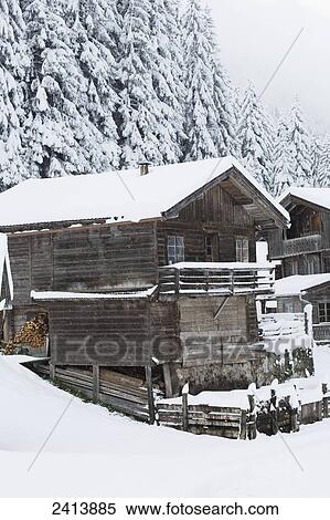 Stock Photography - Snow covering a wooden barn and trees; Hintertux, Austria. Fotosearch
