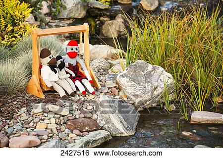 Sock monkeys on a swing beside a stream; Edmonton, Alberta, Canada View Large Photo Image Stock Photograph - Sock monkeys on a swing beside a stream; Edmonton, Alberta, Canada. Fotosearch