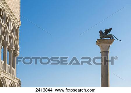 Picture - Statue on top of a column monument against a blue sky; Venice, Veneto, Italy. Fotosearch