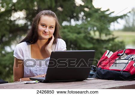Student studying outdoors using a laptop; St. Albert, Alberta, Canada View Large Photo Image Stock Image - Student studying outdoors using a laptop; St. Albert, Alberta, Canada. Fotosearch