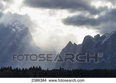 Sun rays breaking though the dark clouds in Grand Teton National Park; Wyoming, United States of America View Large Photo Image Picture - Sun rays breaking though the dark clouds in Grand Teton National Park; Wyoming, United States of America. Fotosearch
