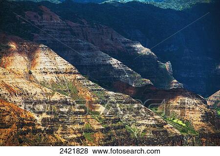 Stock Photo - Sunlight brightens the slopes of the canyons in Waimea Canyon State Park; Kauai, Hawaii, United States of America. Fotosearch