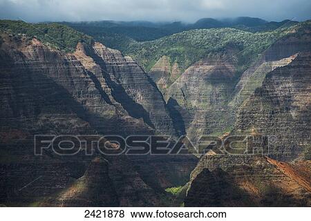Stock Photo - Sunlight brightens the slopes of Waimea Canyon; Kauai, Hawaii, United States of America. Fotosearch