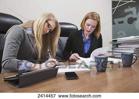Picture - Supervisor and intern working together on an accounting project; Edmonton, Alberta, Canada. Fotosearch - Search Stock Photography, Photos, Prints, Images, and Photo Clipart