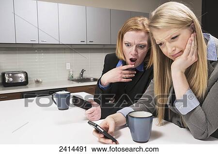 Supervisor shocked at messages on co-worker's smart phone; Edmonton, Alberta, Canada View Large Photo Image Stock Image - Supervisor shocked at messages on co-worker's smart phone; Edmonton, Alberta, Canada. Fotosearch