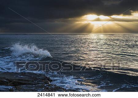 Stock Image - Surf breaks at sunrise; Wailua, Kauai, Hawaii, United States of America. Fotosearch