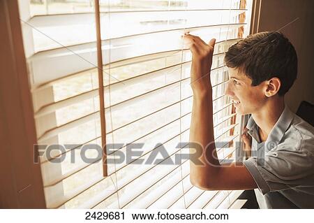 Teen boy looking out his window; Connecticut, United States of America View Large Photo Image Stock Image - Teen boy looking out his window; Connecticut, United States of America. Fotosearch