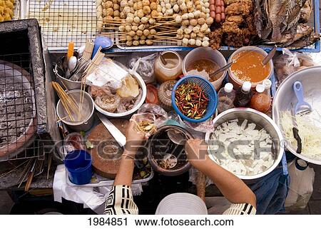 Stock Image - Thailand, Bangkok, View From Above Of A Street Food Stall With Vendor Prepping Food.. Fotosearch